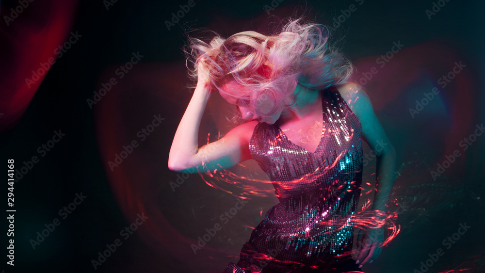 Wall mural attractive dancing blonde in the club, neon light, motion effects