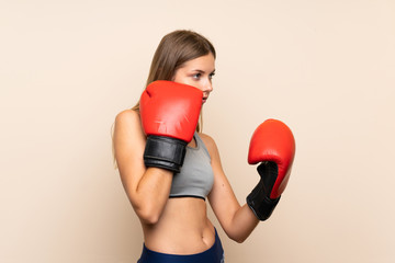 Young blonde girl with boxing gloves over isolated background