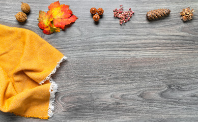 different autumn decorations with a scarf on a wooden board