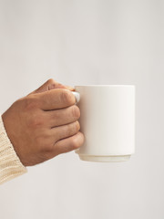 Hand holding a mug mock-up