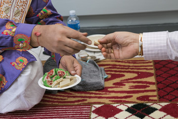 Hinduism ceremony hands passing sweet treats