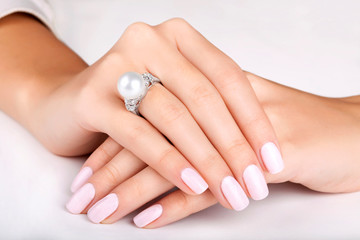 Beautiful female hands with diamond ring with pearl. Beautiful woman's nails with manicure. Diamond ring with pearl. White gold.