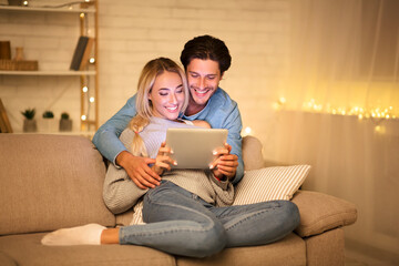 Loving couple chatting with friends on tablet