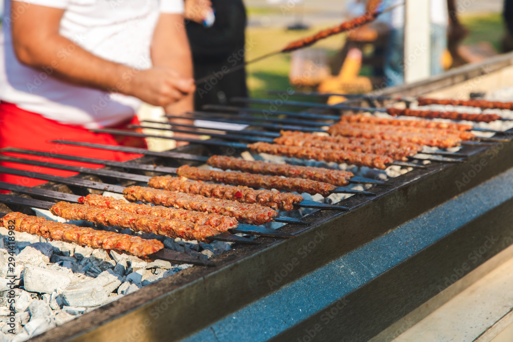 Wall mural traditional turkish adana kebab or kebap on the grill with skewers in the turkish restaurant for din