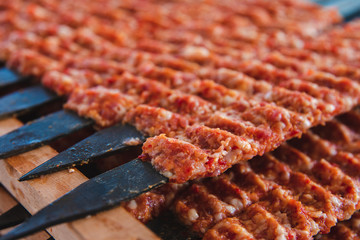 Traditional Turkish Adana Kebab or Kebap meat texture background with skewers in the turkish restaurant for dinner. Turkish cuisine food culture in Turkey.