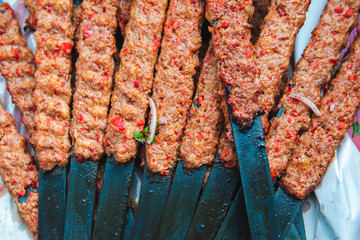 Traditional Turkish Adana Kebab or Kebap on the grill with skewers in the turkish restaurant for...