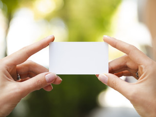Woman holding up a business card mock-up