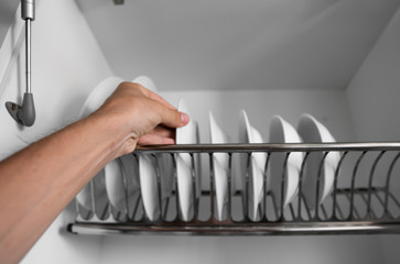 Dish drying metal rack with big nice white clean plates. Traditional comfortable kitchen. Open...