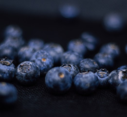Some fresh and healthy blueberries on black background