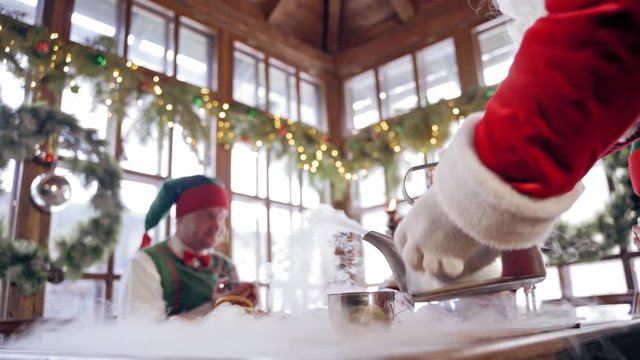 Elves around Santa Claus. Santa Clause and elves having Christmas feast