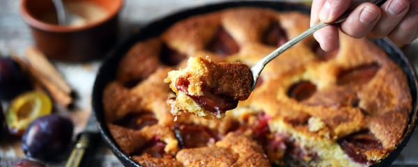 Selective focus. Slice of plum pie on a fork. Homemade American plum pie. Macro.