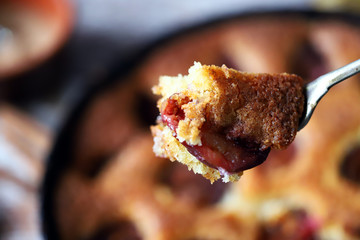 Selective focus. Slice of plum pie on a fork. Homemade American plum pie. Macro.