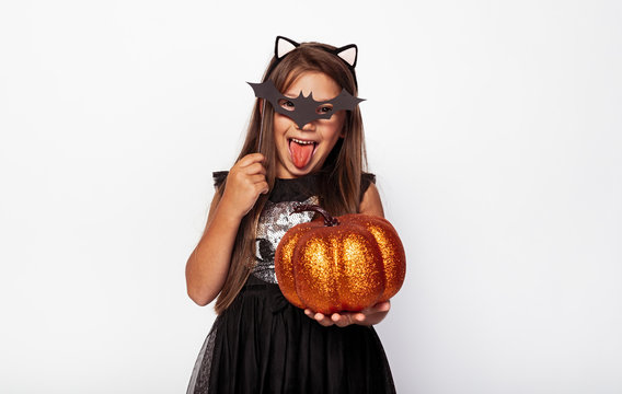 Happy kid with glitter pumpkin and bat mask