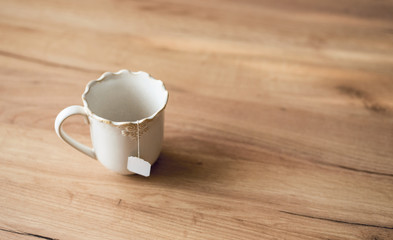 Tea bag in white ceramic cup.