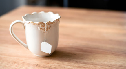 Tea bag in white ceramic cup.