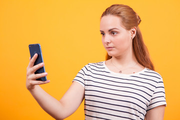 Shocked girl looking into her phone after reading the news