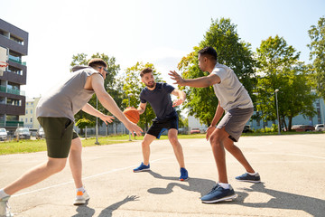 sport, leisure games and male friendship concept - group of men or friends playing street basketball