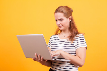 Naklejka premium Conused girl with laptop on his hand in studio