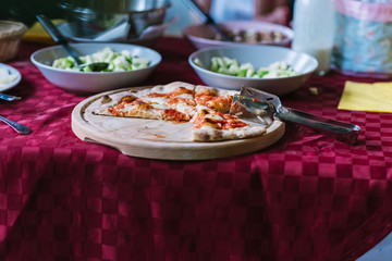 Buffet table with pizza on wooden tray