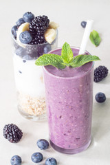 Fototapeta na wymiar Smoothies of banana, blueberry, blackberry, oatmeal and yogurt and ingredients