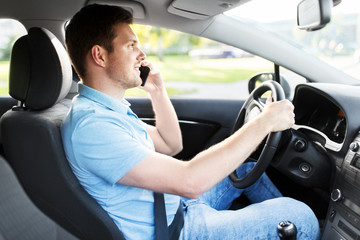 transport, vehicle and people concept - smiling man or driver driving car and calling on smartphone