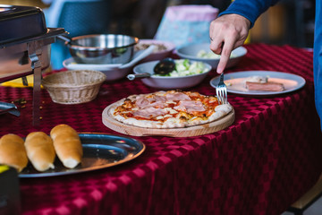 Buffet table with pizza on wooden tray