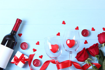 Wine and glasses and hearts on a colored background top view. Background to the day of St. Valentine.