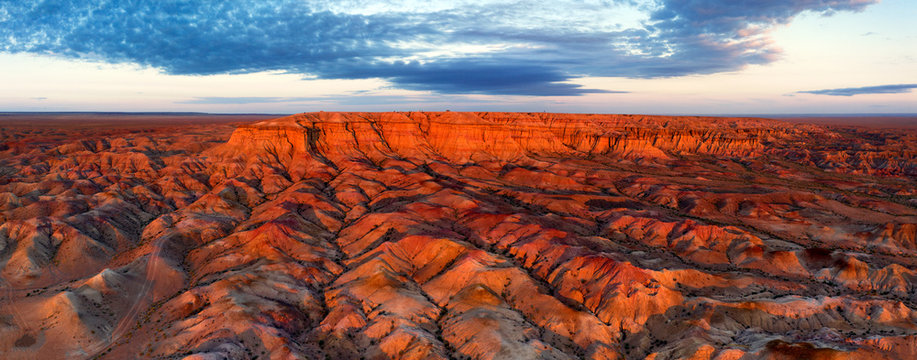 Aerial panorama of textural colorful striped canyons Tsagaan suvarga - White stupa at sunrise. Ulziit soum, Dundgovi province, Mongolia