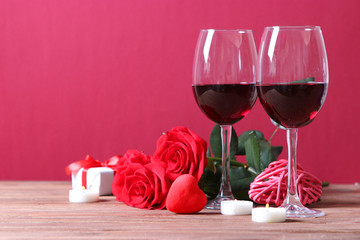 red wine and roses on the table. Valentine's day background. A gala dinner for two.