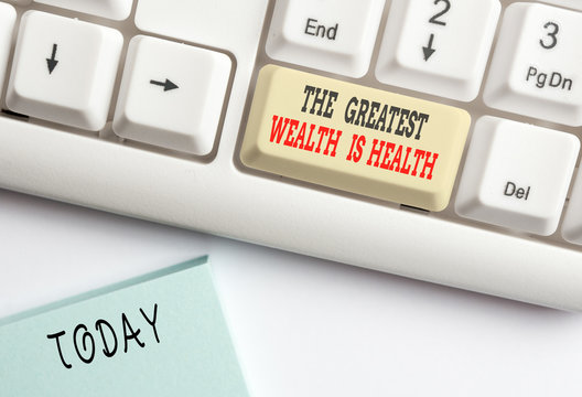Conceptual hand writing showing The Greatest Wealth Is Health. Concept meaning being in good health is the prize Take care White pc keyboard with note paper above the white background