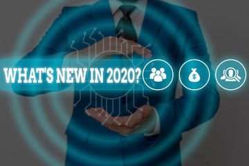 Handwriting text writing What S New In 2020 Question. Conceptual photo Expectation and Surprises for the coming Year Male human wear formal work suit presenting presentation using smart device
