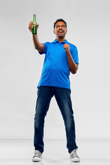 emotion, expression and success concept - happy indian man or sports fan beer bottle celebrating victory over grey background