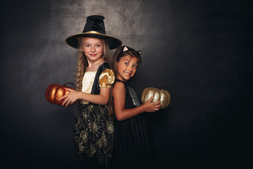 Pretty girls with stylish shiny pumpkins