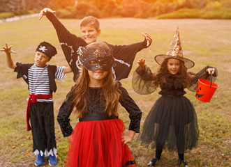 Adorable kids in carnival costumes playing on nature background