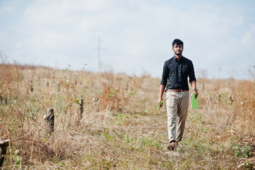 South asian agronomist farmer with clipboard inspecting cut trees in the farm garden. Agriculture production concept.