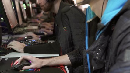 Team of professional e-sportsmen playing competitive video games at the cyber games tournament