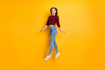 Full length photo of pretty millennial looking with beaming smile wearing burgundy pullover isolated over yellow background