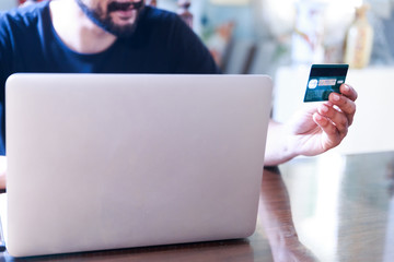 man online shopping using a laptop and a credit card 