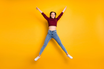 Fototapeta na wymiar Fulll body photo of charming lady raising her arms wearing maroon pullover isolated over yellow background