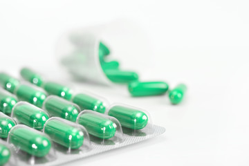 Green capsules on white background, copy-space