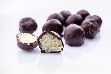 Handmade chocolates with coconut and honey. Gourmet chocolate on a white background. Close-up