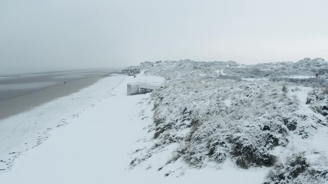 Dunkirk beach in snow, blockhaus, sand dunes and people (Dunkerque, France)