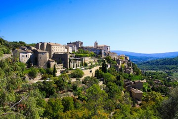 Fototapeta na wymiar Panoramic view on medieval old french village on hill top against blue sky - Gordes, Provence, France