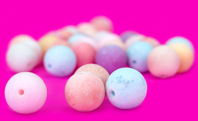 Close up of 3 beads. Set of multi-colored beads on a pink background. Blurred background