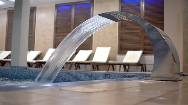 Empty luxury indoor pool with water jet for hydrotherapy