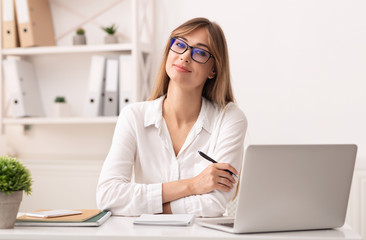 Confident Businesswoman Smiling At Camera Sitting In Modern Office