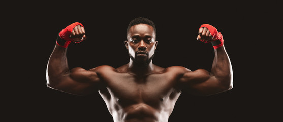 Muscular handsome kickboxer demonstrating his strong biceps