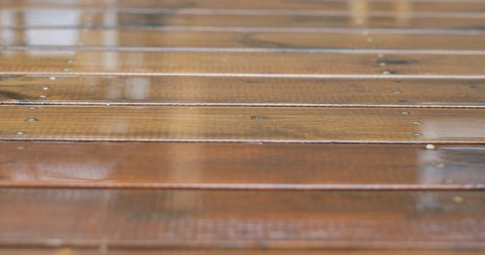 Raindrops fall on the wooden floor