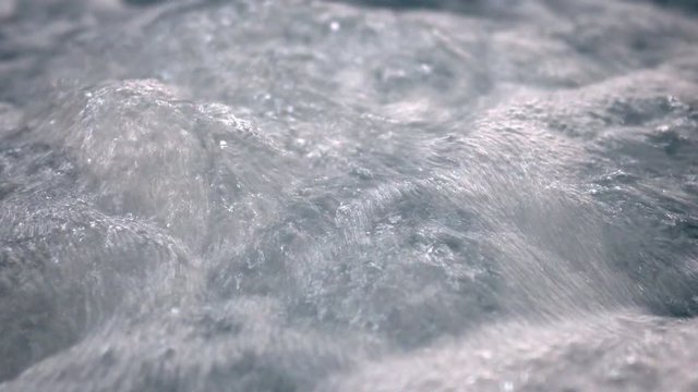 Waves and air bubbles from the jacuzzi jet in the pool