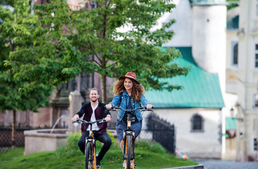 Fototapeta premium Young tourist couple travellers with electric scooters in small town.